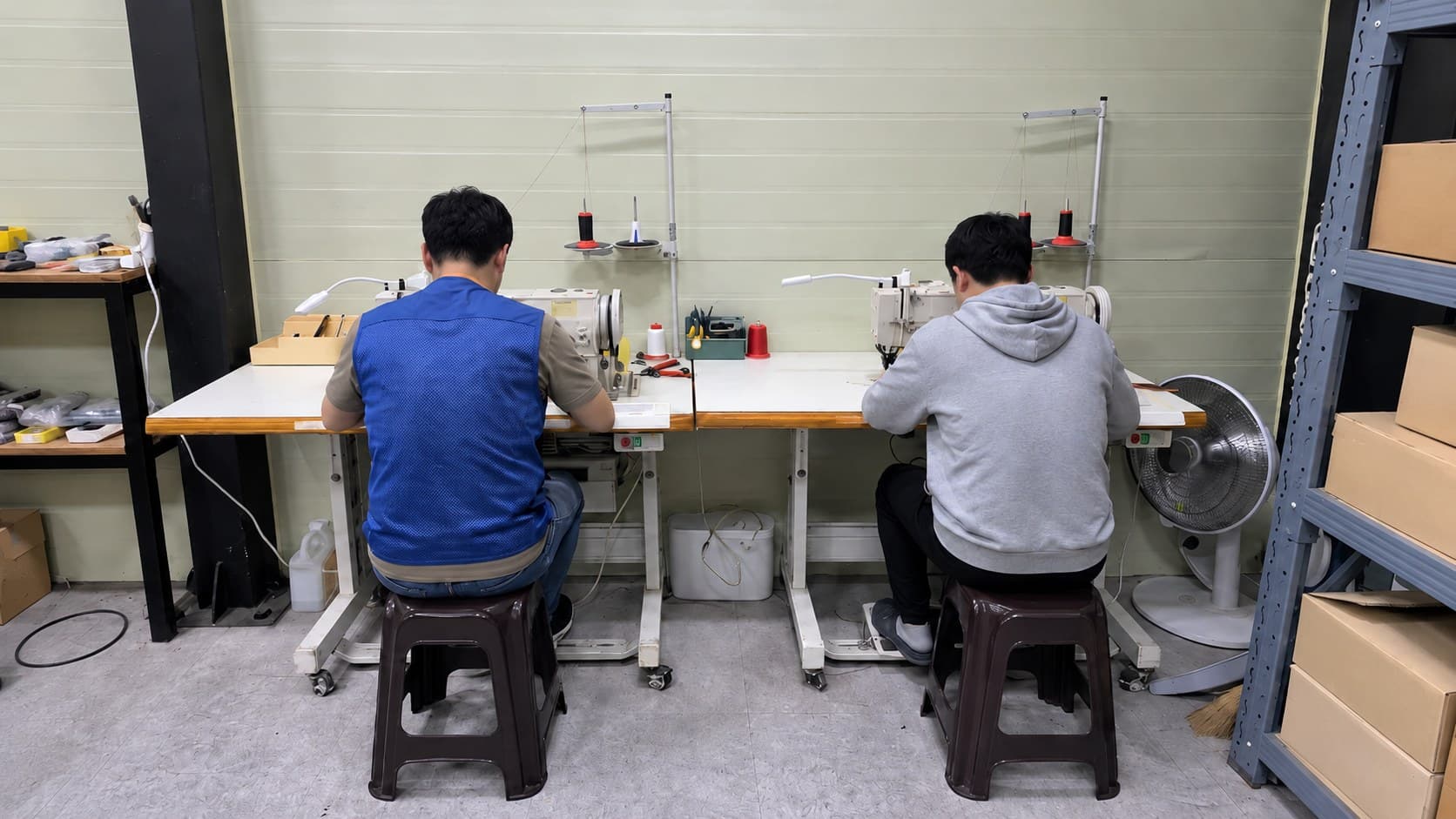 공업용 미싱 두 대 앞에 나란히 앉아 실습하는 교육생 두 명의 뒷모습